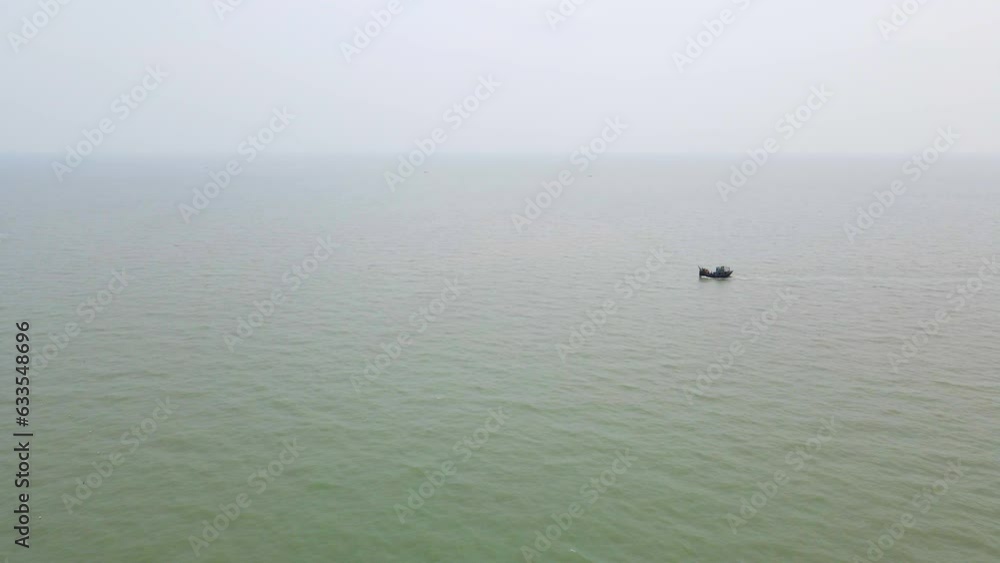 Aerial: Tiny Fishing trawler boat at Bay of Bengal sea water near Bangladesh coast. Indian ocean region. drone flying shot at cloudy day Aerial: Tiny Fishing trawler boat at Bay of Bengal sea water near Bangladesh coast. Indian ocean region. drone flying shot at cloudy day