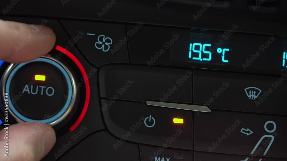 Fingers turn toggle switch of car air conditioner decreasing temperature in cabin to 16 degrees, two-phase climate control in the car Fingers turn toggle switch of car air conditioner decreasing temperature in cabin to 16 degrees, two-phase climate control in the car