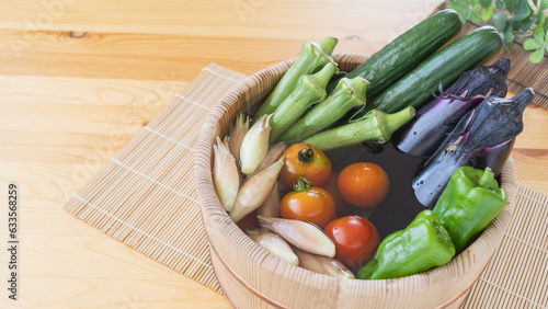 夏野菜イメージ・木桶に水を入れて野菜をつける｜きゅうり・なす・ピーマン・ミニトマト・オクラ・ミョウガ