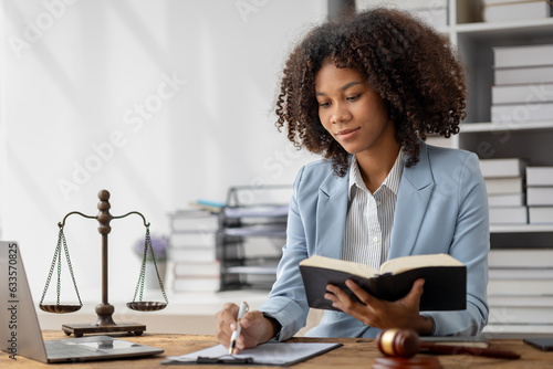 American woman is legal litigation attorney, Female lawyer is in a law firm drafting contracts and reading client case details to study and find a solution to win the case. Lawyer and justice concept.