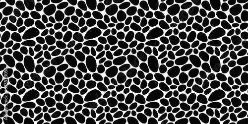Seamless pebbles resembling a leopard skin. The black stones are rounded and provide texture. Pattern of black pebbles.