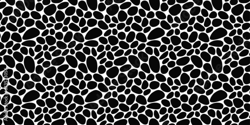 Seamless pebbles resembling a leopard skin. The black stones are rounded and provide texture. Pattern of black pebbles.