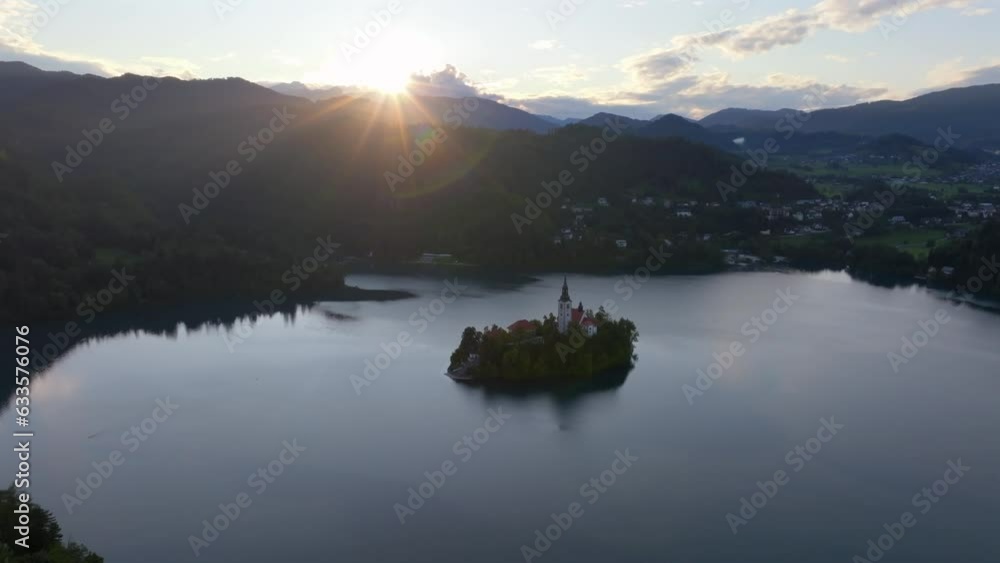 Drone video from Bled Slovenia. A beautifull glaciar lake with a beautifull island in the middle of the lake with sourouding mountains and nature. Filmed at sunset at golden hour. Drone video from Bled Slovenia. A beautifull glaciar lake with a beautifull island in the middle of the lake with sourouding mountains and nature. Filmed at sunset at golden hour.