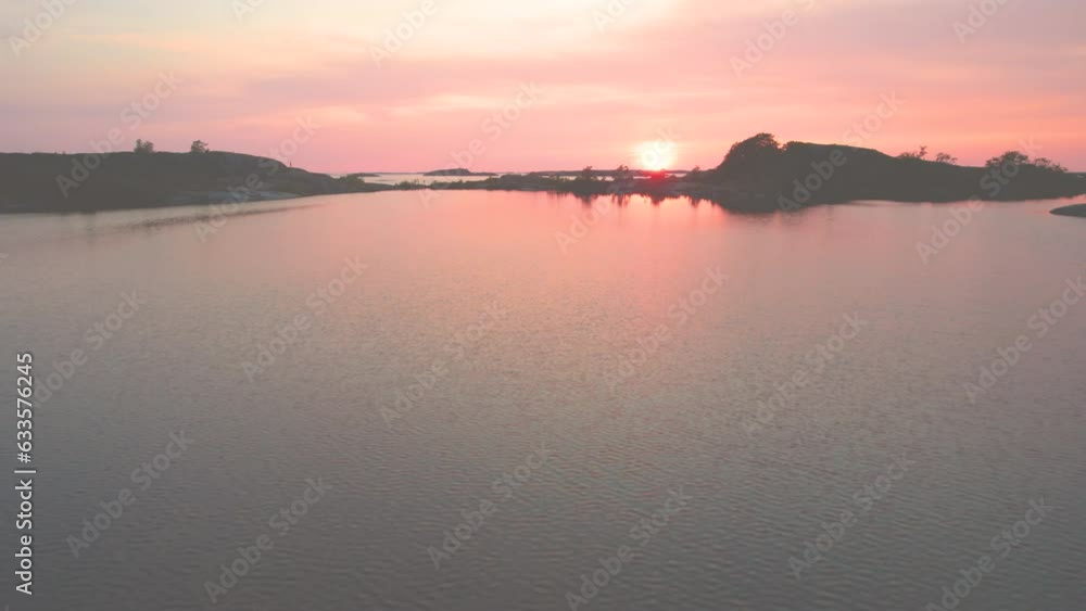 Panning view and flying low over the lake inside the island with calm lake. Sunset in front and opening view to the Baltic Sea. Panning view and flying low over the lake inside the island with calm lake. Sunset in front and opening view to the Baltic Sea.