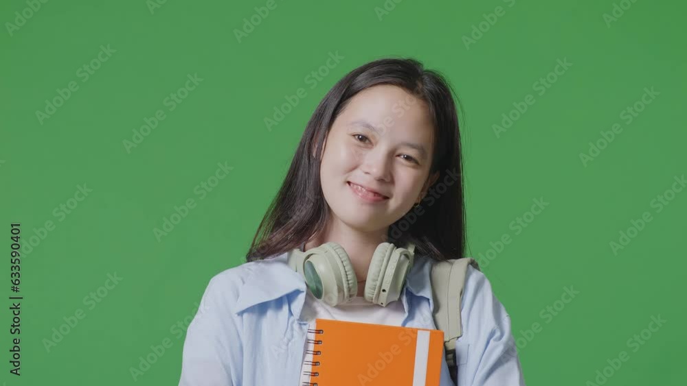 Close Up Of Asian Teen Girl Student With A Backpack Holding Some Books And Smiling To Camera While Standing In The Green Screen Background Studio
Close Up Of Asian Teen Girl Student With A Backpack Holding Some Books And Smiling To Camera While Standing In The Green Screen Background Studio