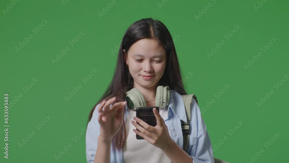 Close Up Of Asian Teen Girl Student With A Backpack Smiling And Using A Smartphone While Walking In The Green Screen Background Studio
Close Up Of Asian Teen Girl Student With A Backpack Smiling And Using A Smartphone While Walking In The Green Screen Background Studio