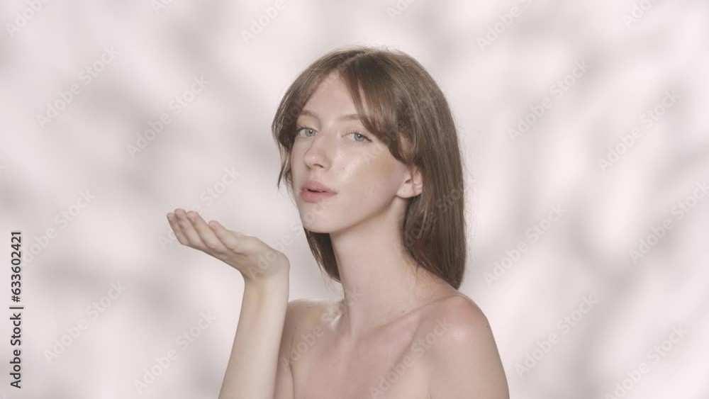 Attractive brunette female model with long hair and blue eyes blowing off the feathers. Slow motion HDR BT2020 HLG Material. Attractive brunette female model with long hair and blue eyes blowing off the feathers. Slow motion HDR BT2020 HLG Material.