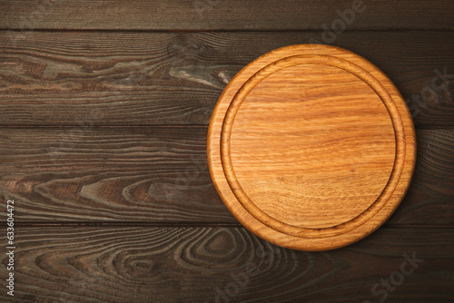 Cutting board on a brown wooden kitchen table.