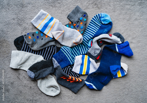Картината върху платно Overhead shot of a pile of mismatched odd socks on gray carpet.