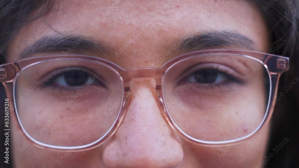 Face of Indian female wearing eye glasses looking up. Close up on eyes. Smart girl wearing glasses. Teenager girl looking at camera. Happy relax. Close up. Slow motion Face of Indian female wearing eye glasses looking up. Close up on eyes. Smart girl wearing glasses. Teenager girl looking at camera. Happy relax. Close up. Slow motion