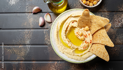 Canvas Print Healthy homemade hummus with olive oil and pita chips. Top view