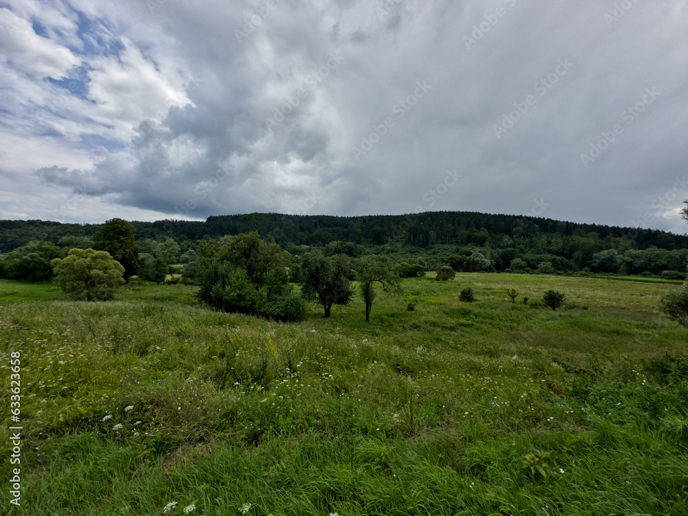 Field and sky. rural areas. Panorama of hills covered with trees with green meadows. Bieszczady, Poland Field and sky. rural areas. Panorama of hills covered with trees with green meadows. Bieszczady, Poland