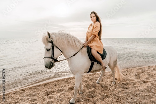 A white horse and a woman in a dress stand on a beach, with the sky and sea creating a picturesque backdrop for the scene.