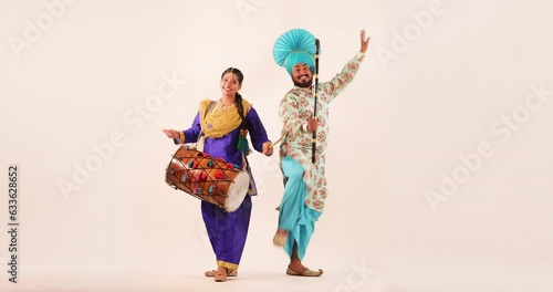 Sikh couple performing bhangra with khunda and drum during Baisakhi Celebration