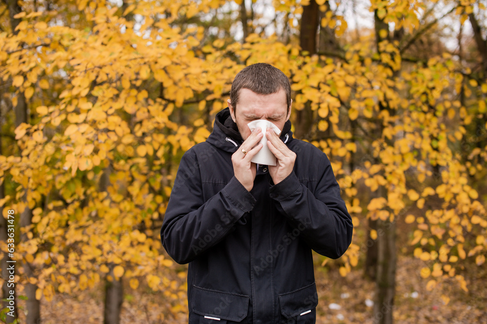 A man holds a napkin near his nose