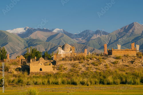 This evocative scene captures the region's spiritual heritage against its breathtaking natural backdrop. Sunset Serenity at Semiz Bel Muslim Cemetery, Kochkor, Kyrgyzstan photo