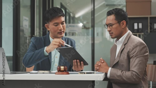Two disgusting businessmen Asian lawyer of Indian descent paying attention to mistakes, proposing corrections. Businessman discussing contract policy terms with client, rights of liberty concept.