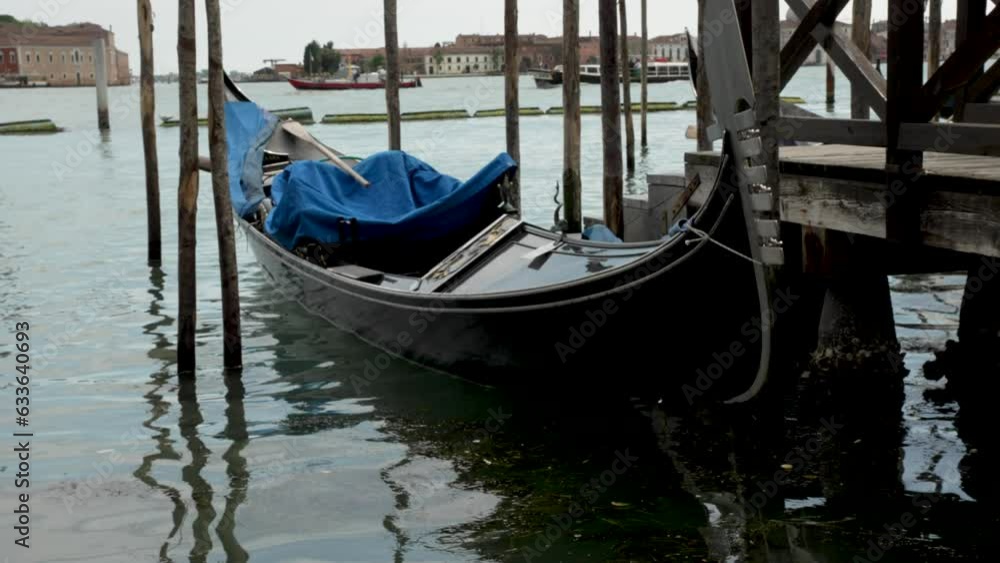 Traditional gondola boat parked on grand canal in Venice, Italy.Static medium Traditional gondola boat parked on grand canal in Venice, Italy.Static medium