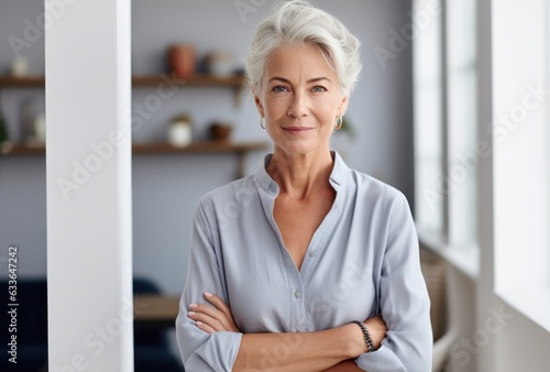 Attractive elderly woman standing in office at home