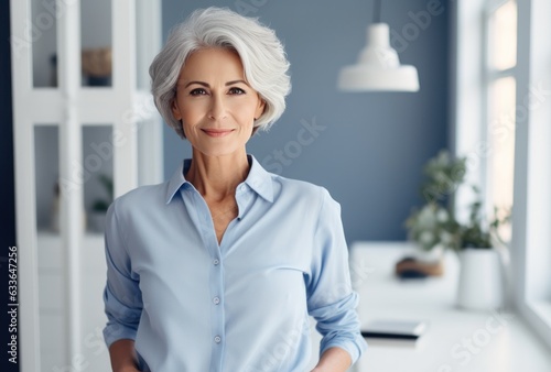 Attractive elderly woman standing in office at home