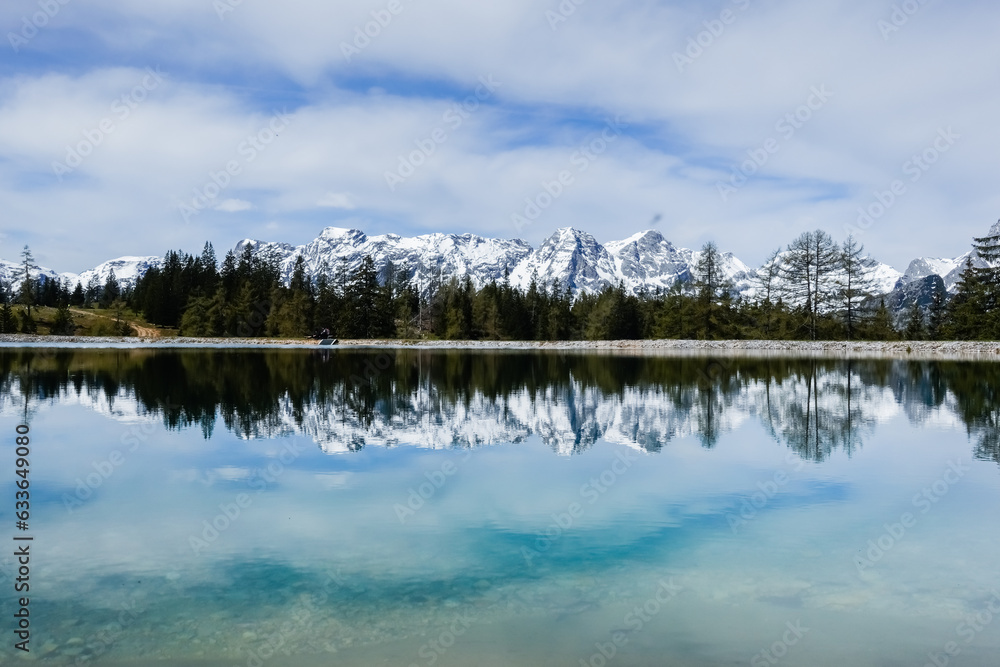 view to a wonderful snowy mountain range with reflections from a lake