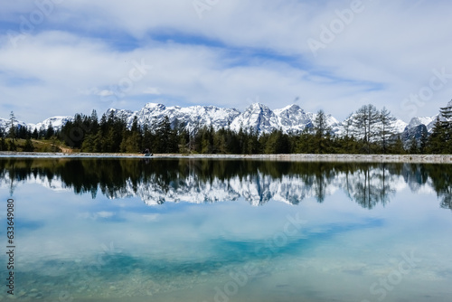 view to a wonderful snowy mountain range with reflections from a lake