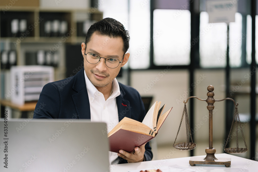 Legal counsel reading a book legislation at desk in office. Legal counsel reading a book legislation at desk in office.