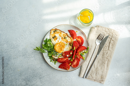 Healthy lunch with fried eggs and tomatoes slices photo