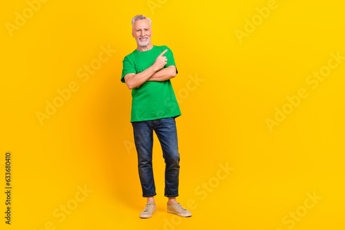 Full size photo of cheerful nice aged man indicate finger empty space proposition isolated on yellow color background
