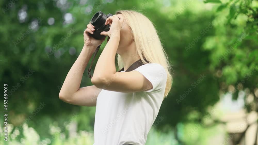 Portrait of pretty young blond woman photographer hold digital camera taking photos and looking around at green park Charming young tourist female taking pictures during vacation outdoors Portrait of pretty young blond woman photographer hold digital camera taking photos and looking around at green park Charming young tourist female taking pictures during vacation outdoors