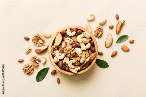 mixed nuts in bowl. Mix of various nuts on colored background. pistachios, cashews, walnuts, hazelnuts, peanuts and brazil nuts photo