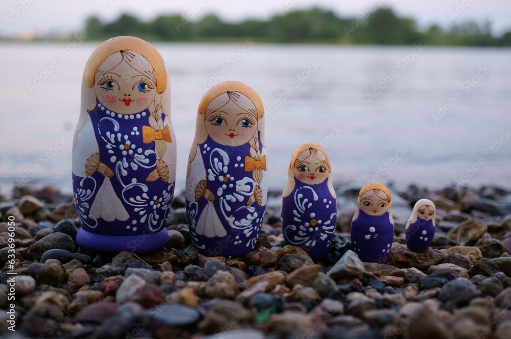A group of nesting dolls on the river bank.