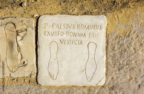 Votive plaques on the floor of the Porta Triumphalis, one of the access gates to the Italica Amphitheater. Roman city of Italica, located in Santiponce, Seville, Andalusia, Spain. photo