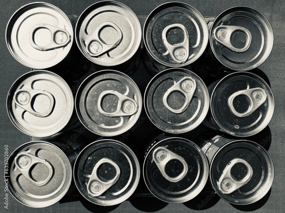 arranged tin cans with opener from above in black and white arranged tin cans with opener from above in black and white