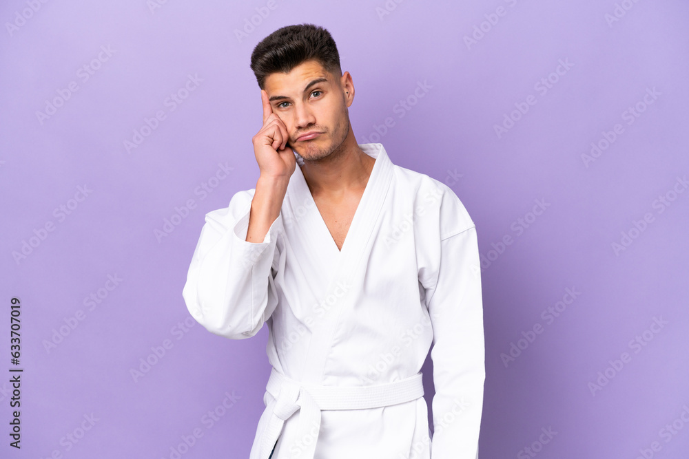 Young caucasian man doing karate isolated on purple background thinking an idea Young caucasian man doing karate isolated on purple background thinking an idea