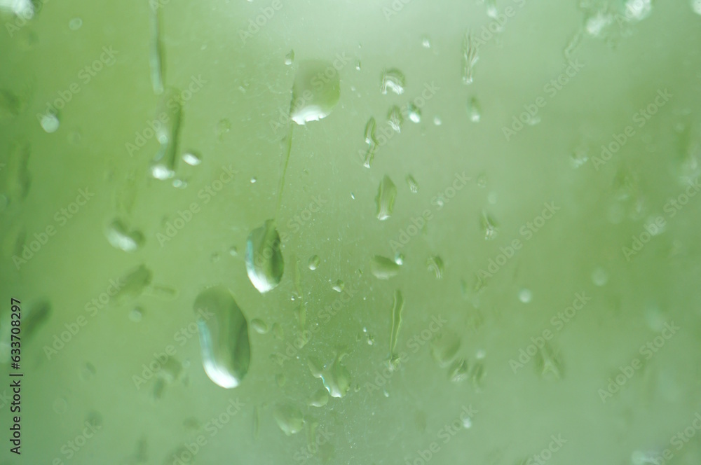 Drops on the window pane. Background image. Green tone.