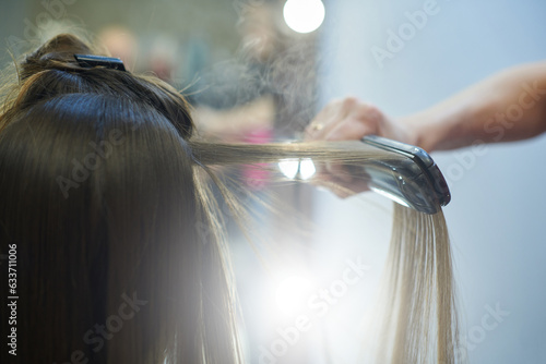 Tableau sur toile Hair straightening with keratin and a hair iron