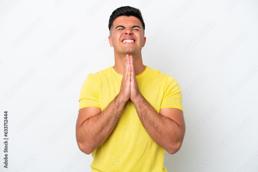 Young caucasian handsome man isolated on white background keeps palm together. Person asks for something Young caucasian handsome man isolated on white background keeps palm together. Person asks for something