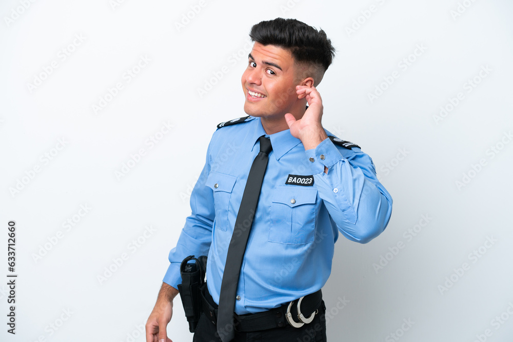 Young police caucasian man isolated on white background listening to something by putting hand on the ear Young police caucasian man isolated on white background listening to something by putting hand on the ear