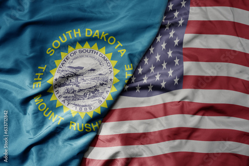 big waving colorful national flag of united states of america and flag of south dakota state .