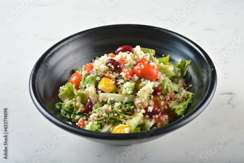 couscous healthy grain salad bowl with corn, bean, carrot and salad dressing sauce on white marble table background chef cook healthy poke bowl halal vegan food menu
