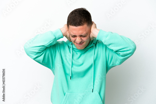 Young brazilian man isolated on white background frustrated and covering ears © luismolinero