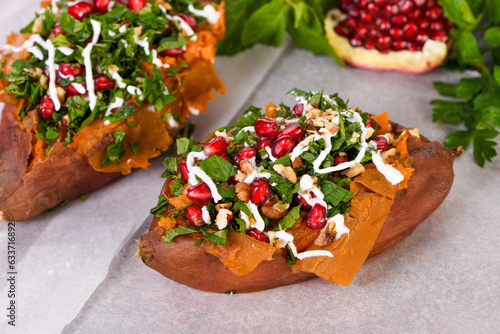 Photography Baked stuffed sweet potatoes filled with walnuts, fresh herbs, mint and pomegranate seeds