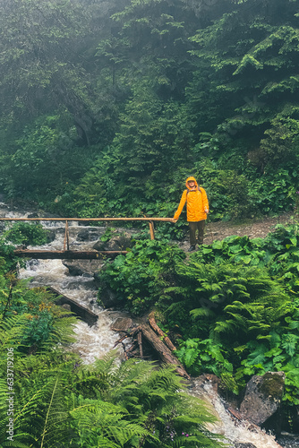 Wallpaper Mural man in yellow raincoat at mountain trail Torontodigital.ca