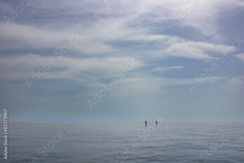 Paddleboarder by the coast of Sicily enjoying the calm morning waters
