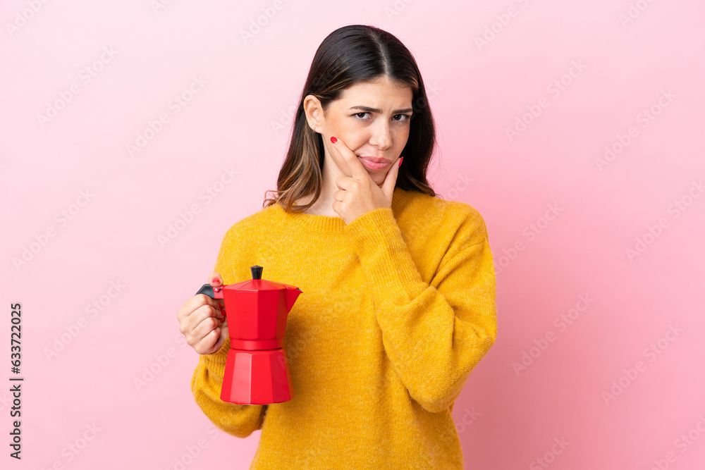 Young Italian woman holding a coffee maker isolated on pink background thinking Young Italian woman holding a coffee maker isolated on pink background thinking
