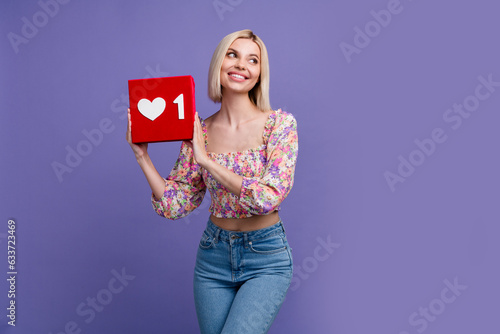Portrait of lovely positive minded girl arms hold like notification icon look empty space isolated on purple color background