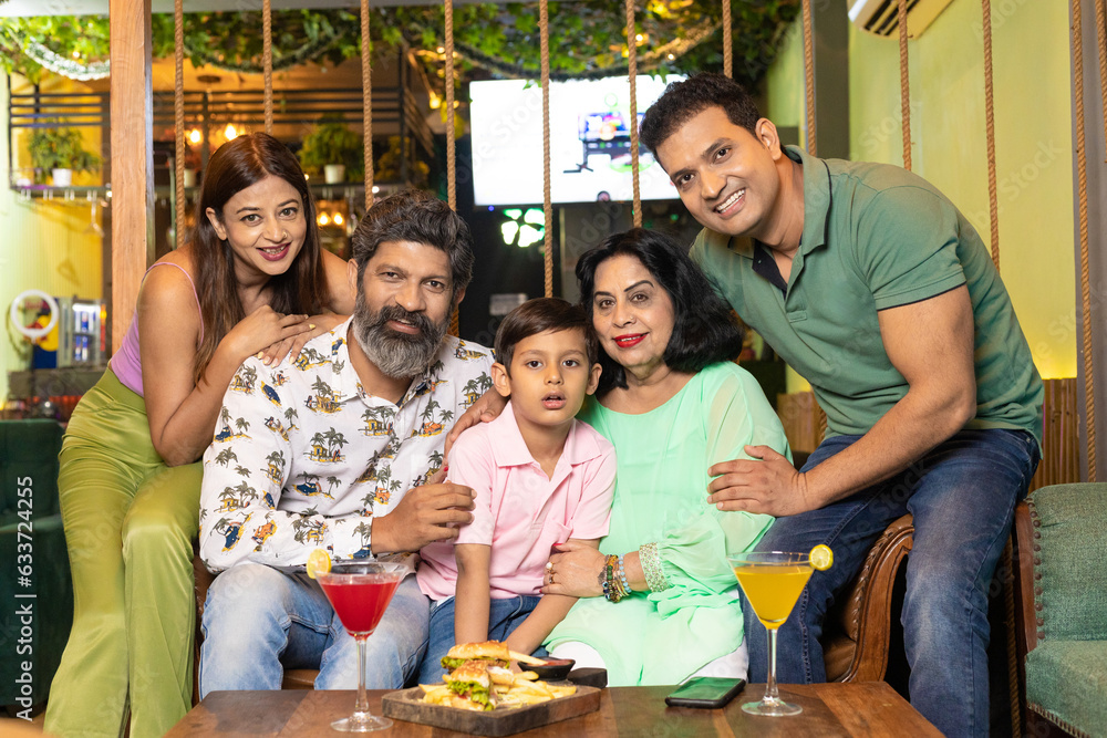 Indian family giving happy expression at restaurant.