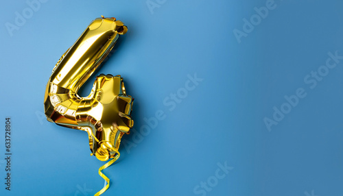 Banner with number 4 golden balloon with copy space. Four years anniversary celebration concept on a blue background.