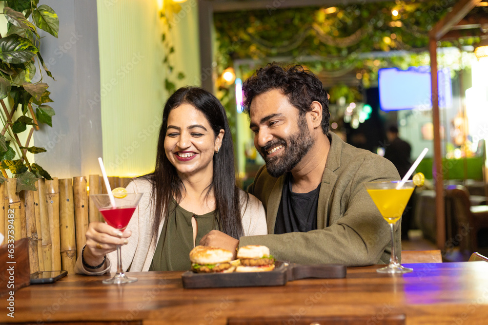 Indian Couple enjoying food and drink at restaurant